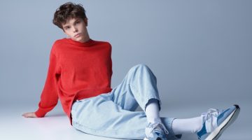 young man sneakers red sweater studio