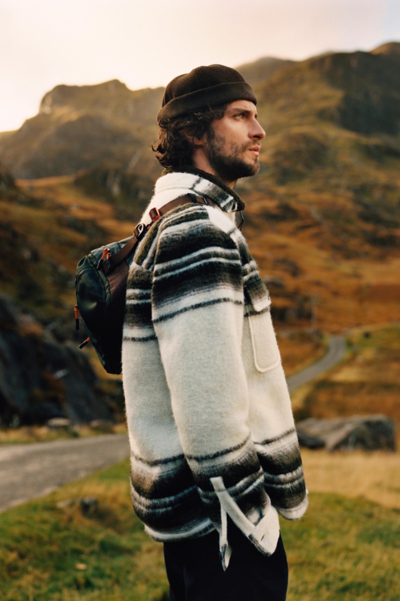 Matthew Bell wears a striped overshirt with cargo pants and a nylon sport crossbody bag.