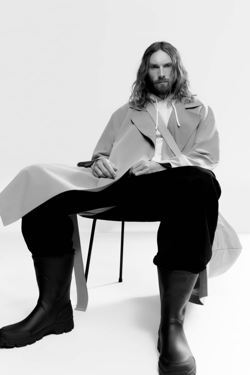 Sitting for a photo, Aiden Andrews models Tretorn x Zara black rain boots.