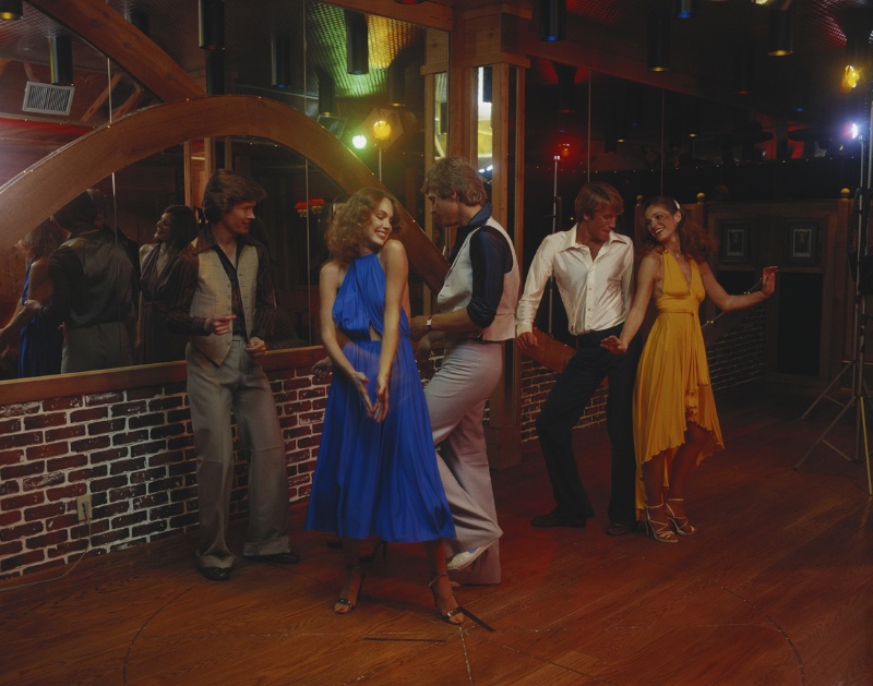 Couples dance the night away in trendy 70s disco styles.