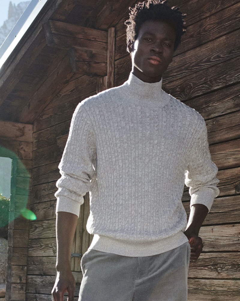 A chic vision, Felix Owusu models a cable-knit turtleneck sweater. 