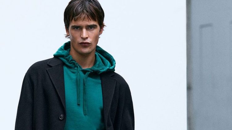 Parker van Noord dons a single-breasted coat with a green hoodie.