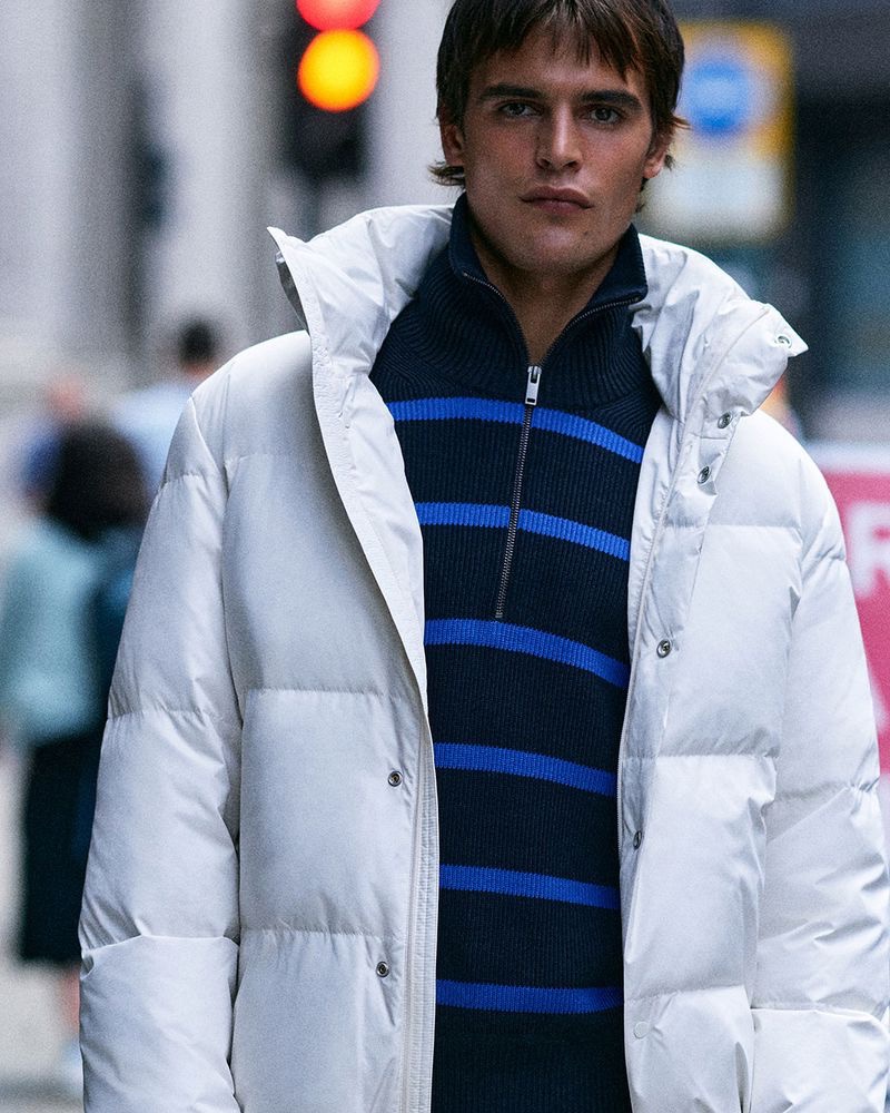 Ready for winter, Parker van Noord slips on a white puffer with a striped 3/4 zippered pullover.