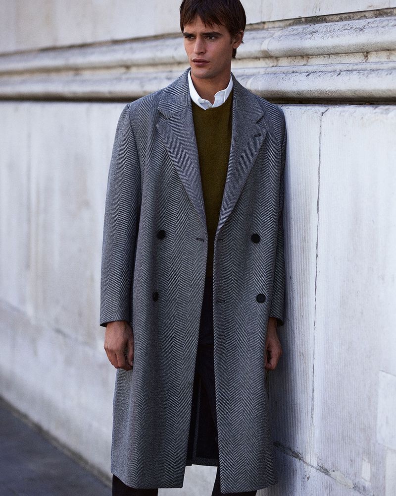 Connecting with COS, Parker van Noord dons a double-breasted herringbone coat.