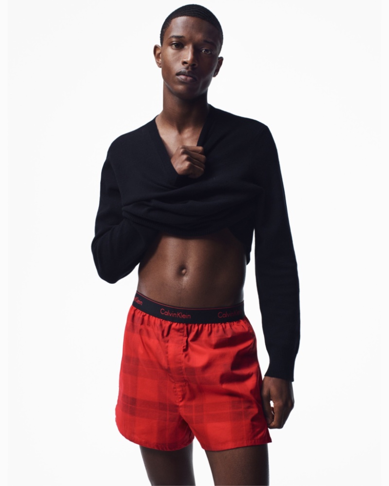 Malik Anderson wears limited-edition slim-fit boxers in a red buffalo plaid for Calvin Klein's holiday 2022 campaign.