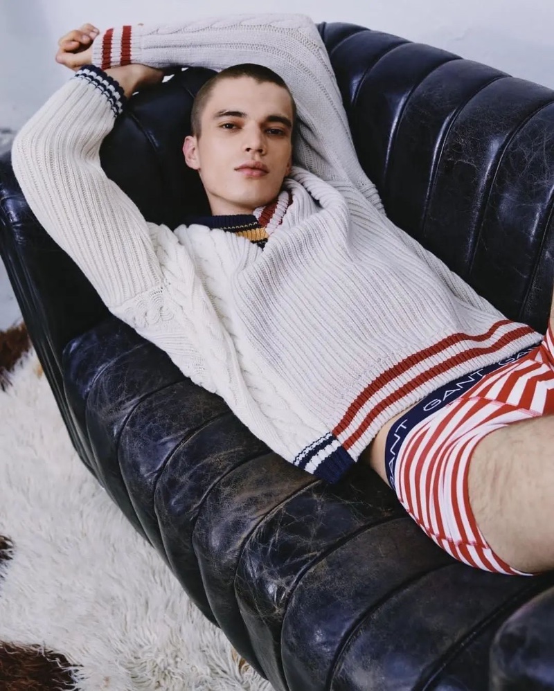 Sporting a cable-knit sweater and striped underwear, Dalibor Urosevic embraces a red, blue, and white theme for GANT's fall-winter 2022 underwear campaign.