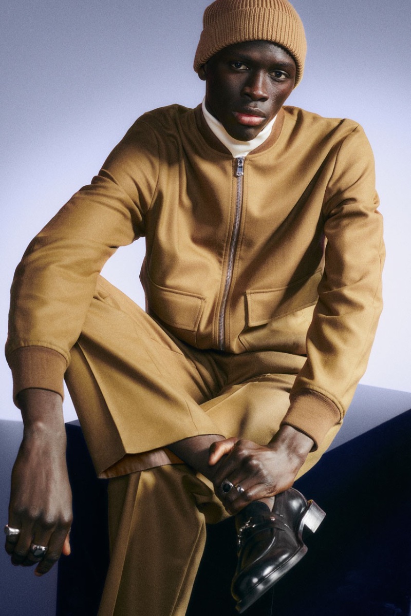 Khadim Sock makes a case for monochrome style in a camel-toned ensemble for J.Lindeberg's holiday 2022 campaign.