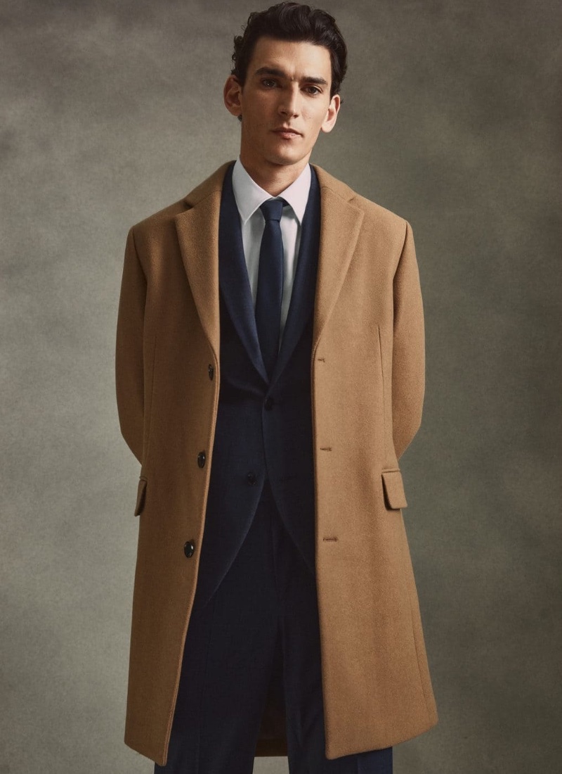 Thibaud Charon dons Mango's camel coat with an elegant suit, shirt, and tie. » Mango Suits: Thibaud Dresses Up for the Occasion Thibaud Charon dons Mango's camel coat with an elegant suit, shirt, and tie.