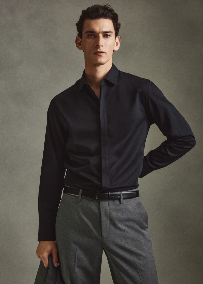 French model Thibaud Charon wears a Mango dress shirt in black with gray pleated suit trousers.