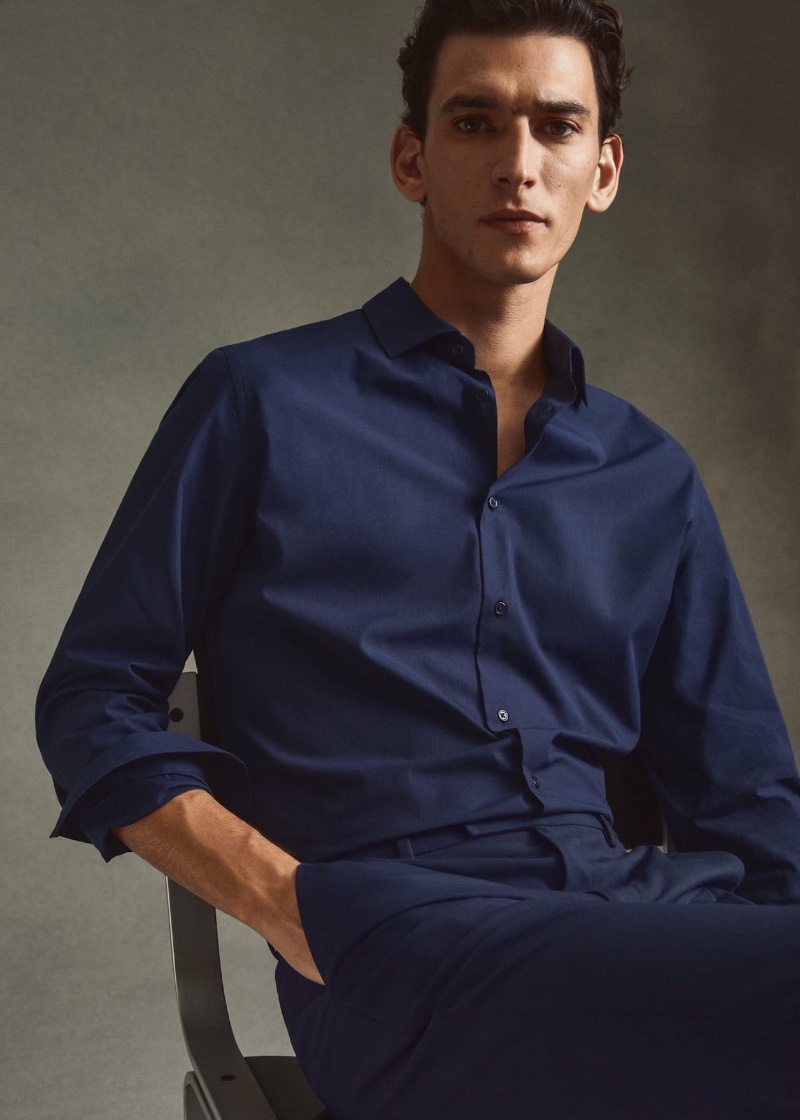 Embracing monochrome style, Thibaud Charon wears a navy dress shirt and trousers by Mango.