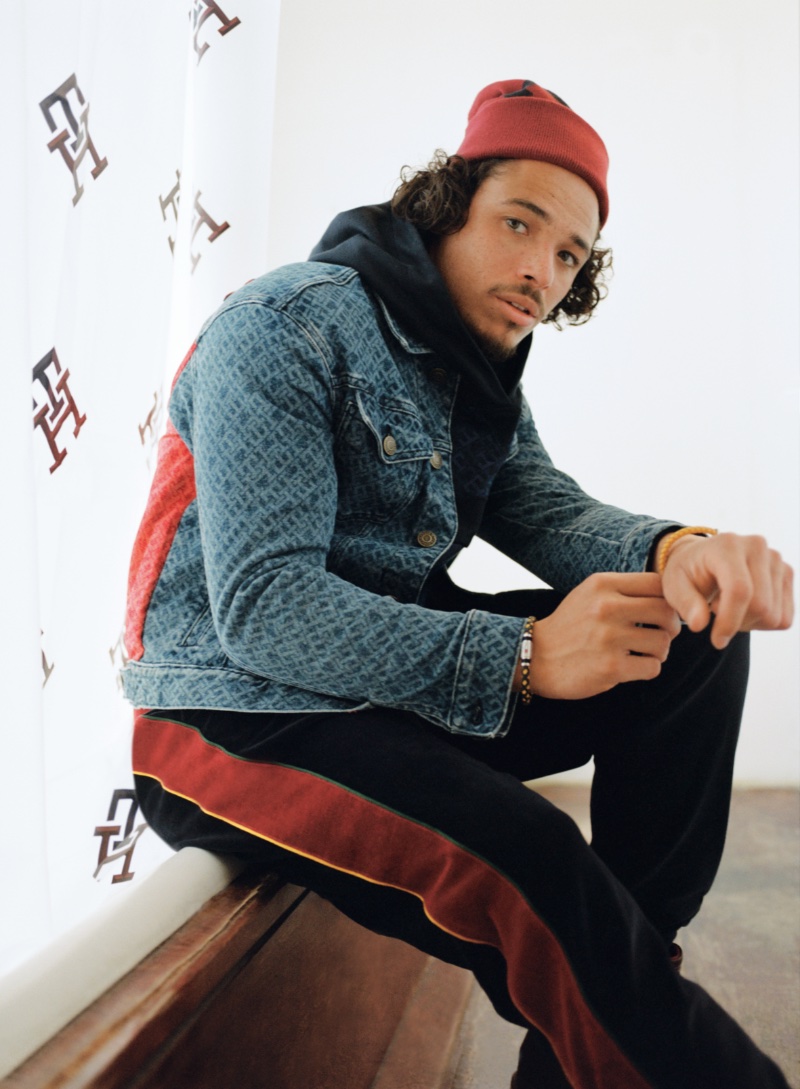Anthony Ramos wears a monogram denim trucker jacket with velour track pants from his Tommy Hilfiger holiday 2022 capsule collection.