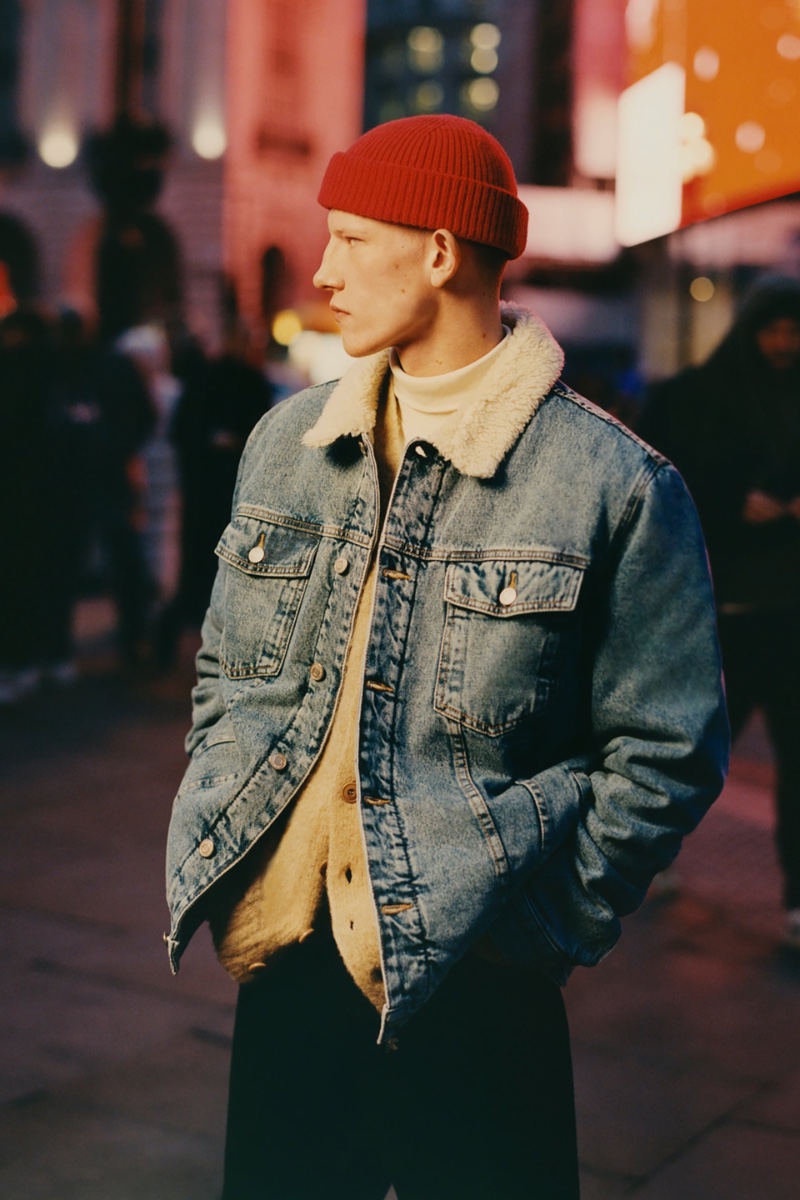 Connor Newall layers a denim jacket with a fleece collar over a cardigan sweater and turtleneck.