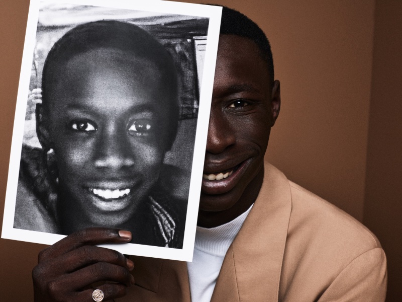 All smiles, Khaby Lame poses with a picture of himself younger for BOSS' spring 2023 campaign.