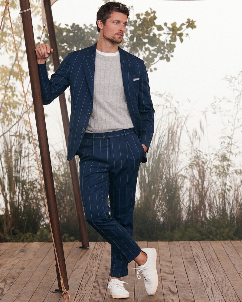 Smashing in navy, Wouter Peelen dons a pinstripe suit with a lightweight cable-knit sweater and off-white sneakers. 