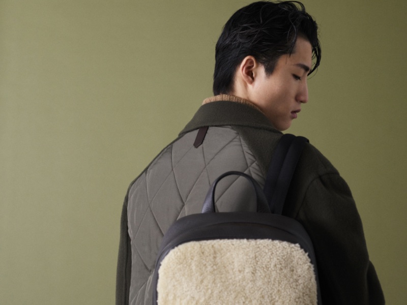 Model Young Woong Kim wears a backpack from Canali's fall-winter 2023 collection. 