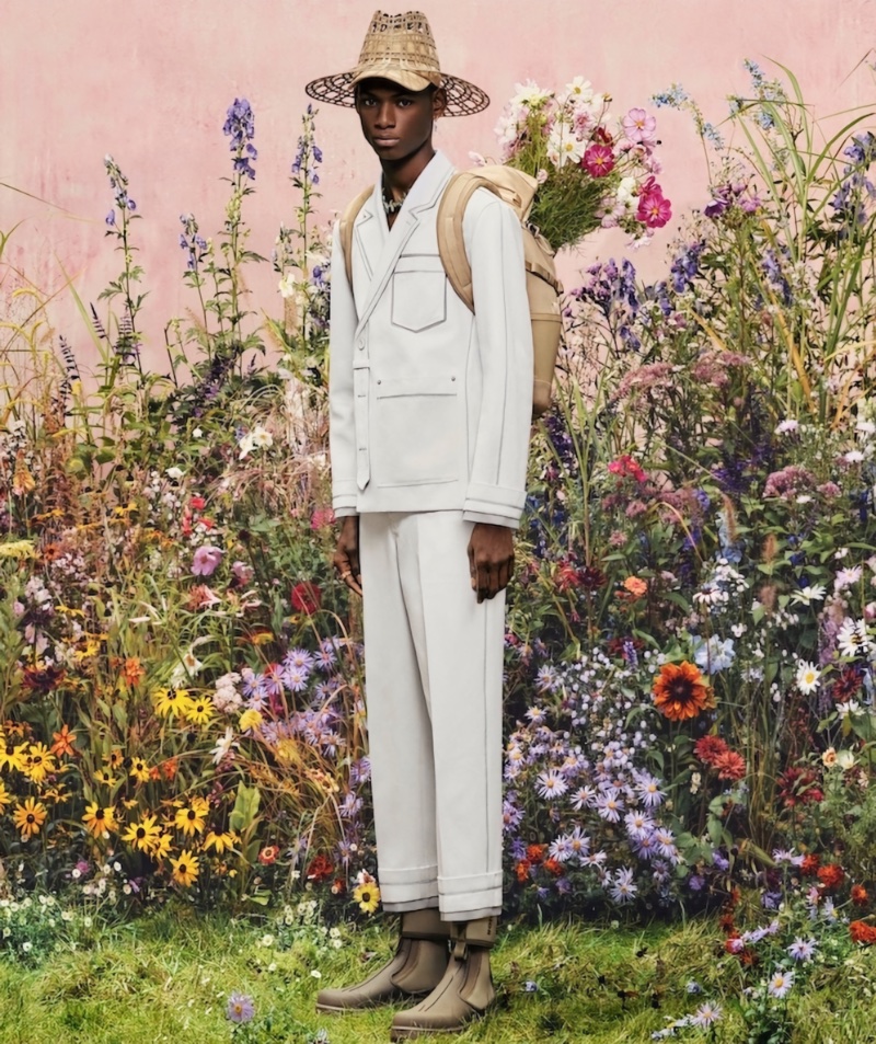 Godwin Alwell Okereuku is a sleek vision in a white suit and straw hat for Dior Men's spring 2023 campaign.