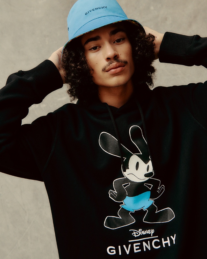 Lucian Príeto-Sánchez wears a Givenchy bucket hat with a Givenchy x Disney hoodie. 
