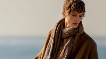 Leon Dame dons a light scarf with a brown jacket and white jeans for Loro Piana's spring-summer 2023 campaign.