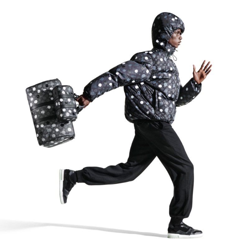 On the move, Malick Bodian sports a hooded jacket and accessories from the new Louis Vuitton x Yayoi Kusama collection.