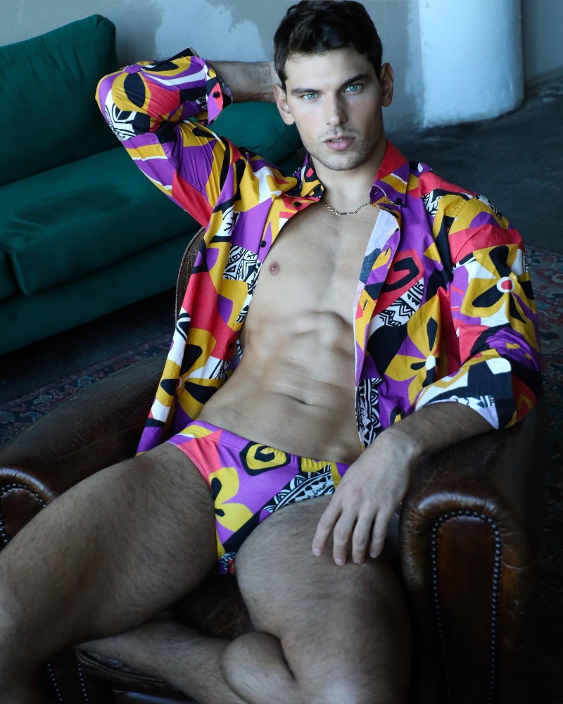 Embracing color in a CO-ORD fashion, Stefano Marshall models a Moschino shirt and swimsuit.