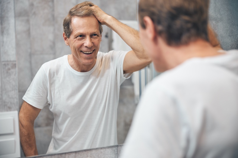 Older Man Touching Hair Bathroom