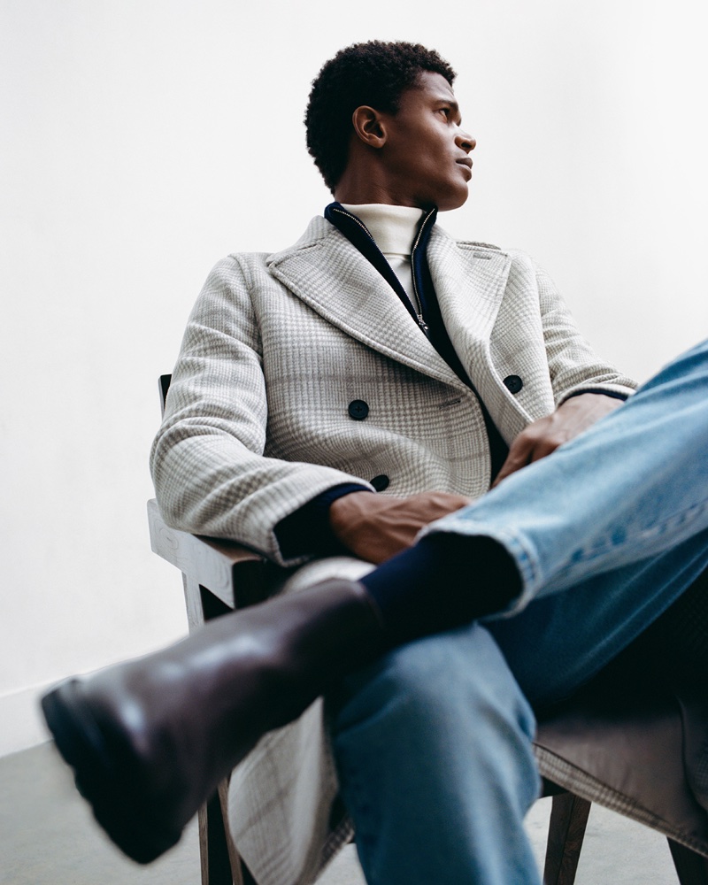 A chic vision, O'Shea Robertson dons a plaid double-breasted coat over a 3/4 zip pullover and turtleneck with denim jeans and leather boots. 