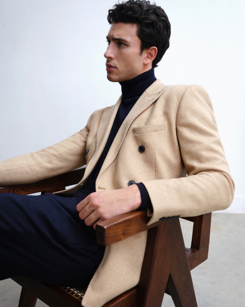 Mattia Narducci inspires in a sleek tan-colored double-breasted coat with a black turtleneck and navy trousers.