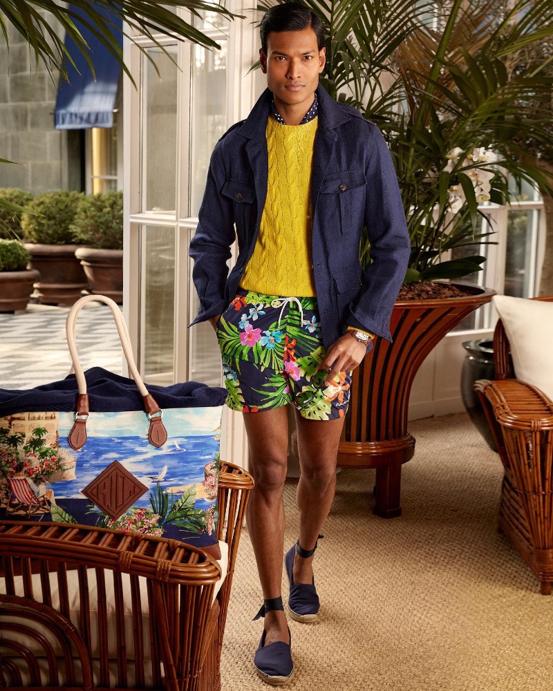 Joy Islam stands out in a yellow cable-knit sweater and tropical print swim shorts from Ralph Lauren Purple Label's resort 2023 collection. 