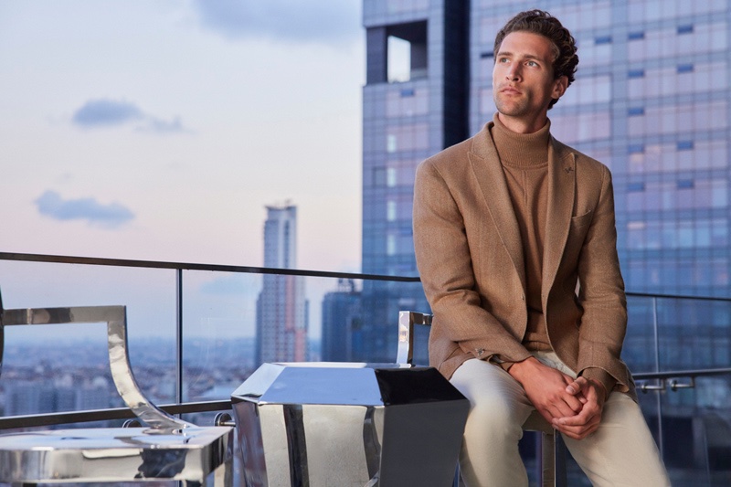 Wearing a neutral color scheme, Fabrizio Silva wears a Ramsey turtleneck with a suit jacket and trousers.