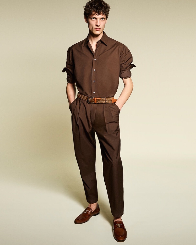 Valentin Caron makes a case for monochrome style in a brown shirt with pleated trousers for Tod's pre-spring 2023 campaign.