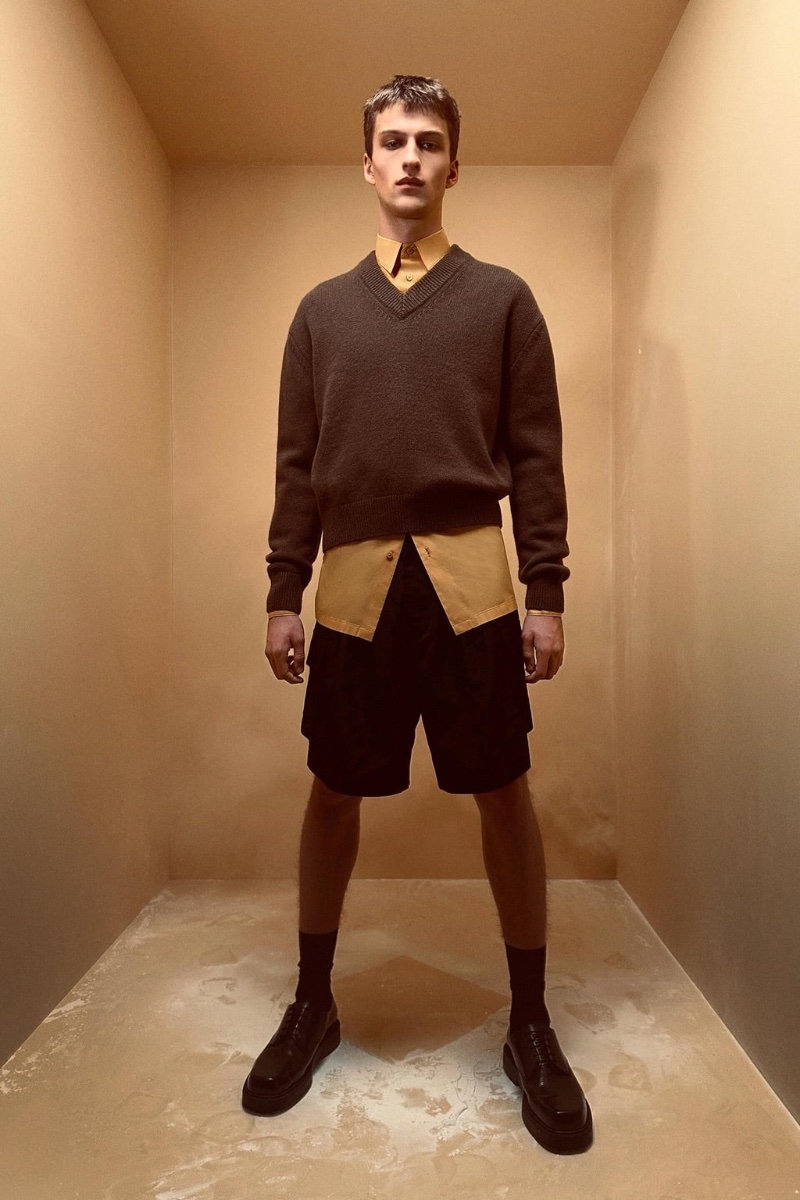 Vasko Luyckx wears a wool v-neck sweater over a shirt and shorts from the Zara Edition spring-summer 2023 collection.