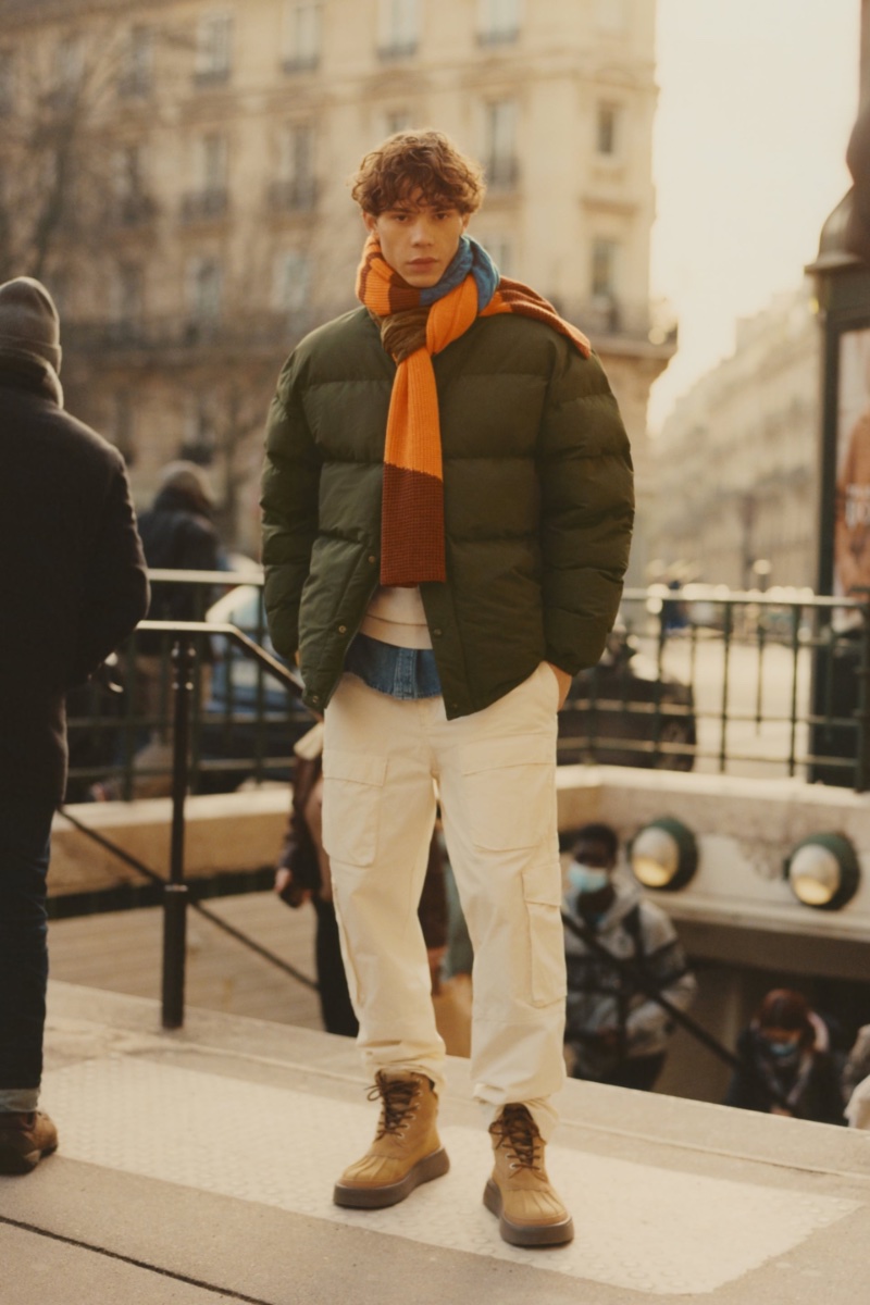 Jonathan Frenzel models a quilted jacket with cargo pants and a multicolored scarf. 