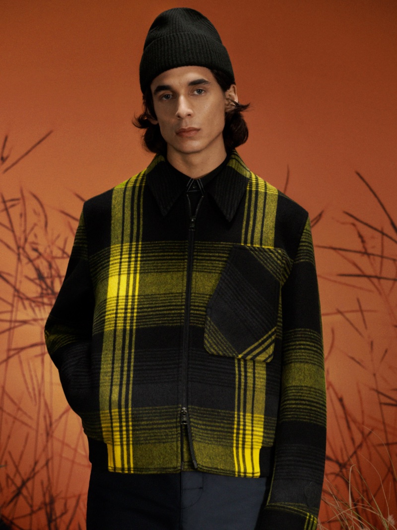 Donovan Wildfong sports a yellow and black plaid jacket from the COS x YEBOAH Metamorphosis collection. 