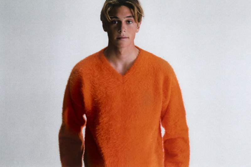 Cole Alves wears a bright orange brushed sweater by ERL.