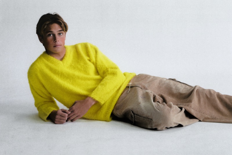 Evoking throwback style, Cole Alves rocks a lemon yellow brushed sweater by ERL.