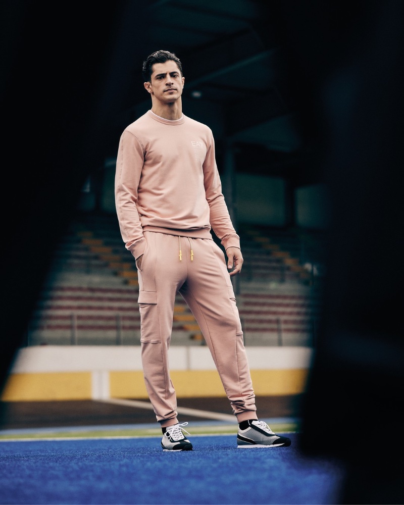Cyrus Amini sports a matching sweatshirt and joggers by EA7. 
