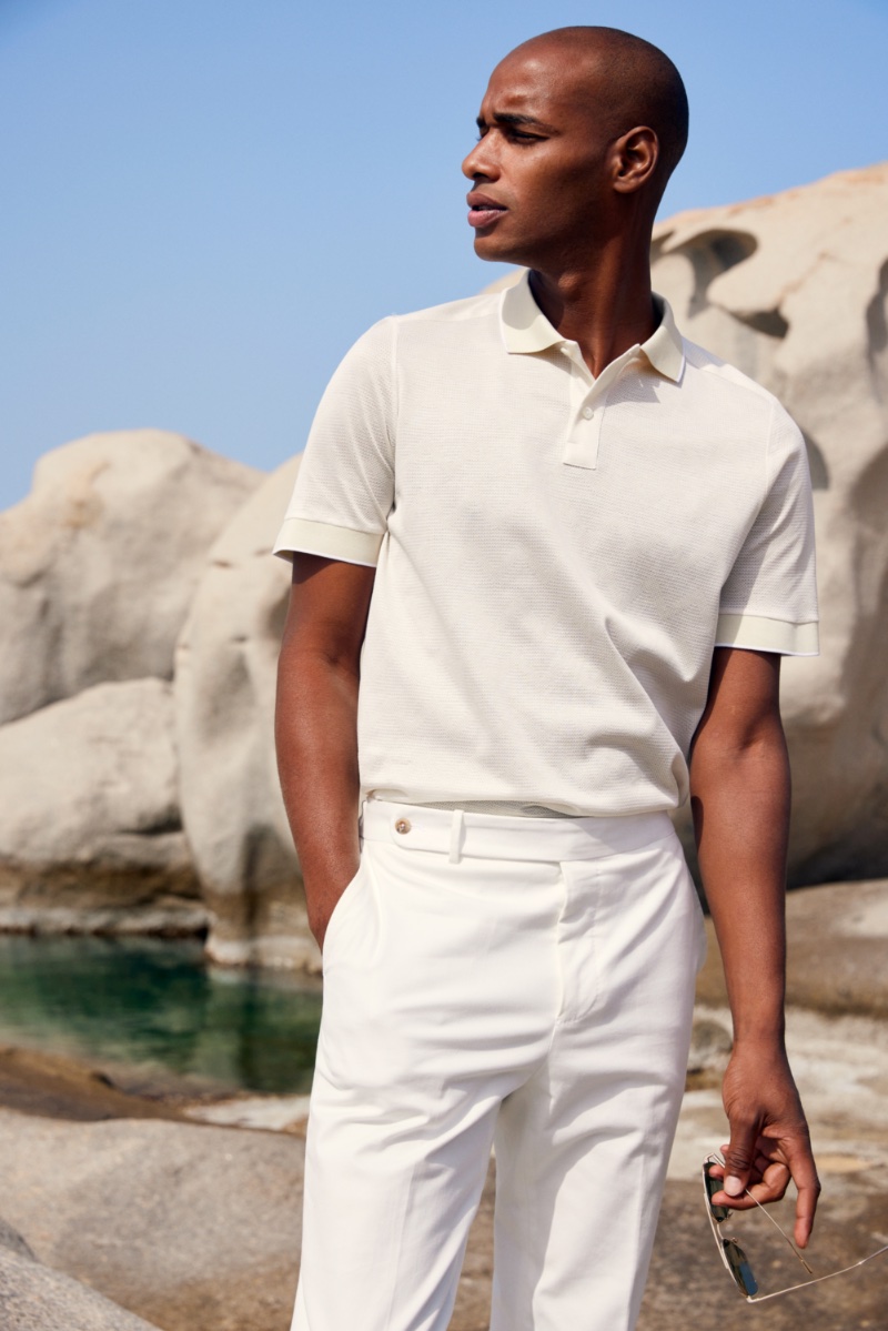 Wearing all white, Sacha M'Baye sports a smart polo for Eton's spring-summer 2023 campaign. » Eton's New Collection Celebrates the Beauty of Sardinia Wearing all white, Sacha M'Baye sports a smart polo for Eton's spring-summer 2023 campaign.