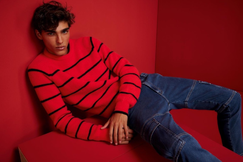 Sporting a striped red sweater with carpenter jeans, Simone Stravolo rocks fashions from HUGO.