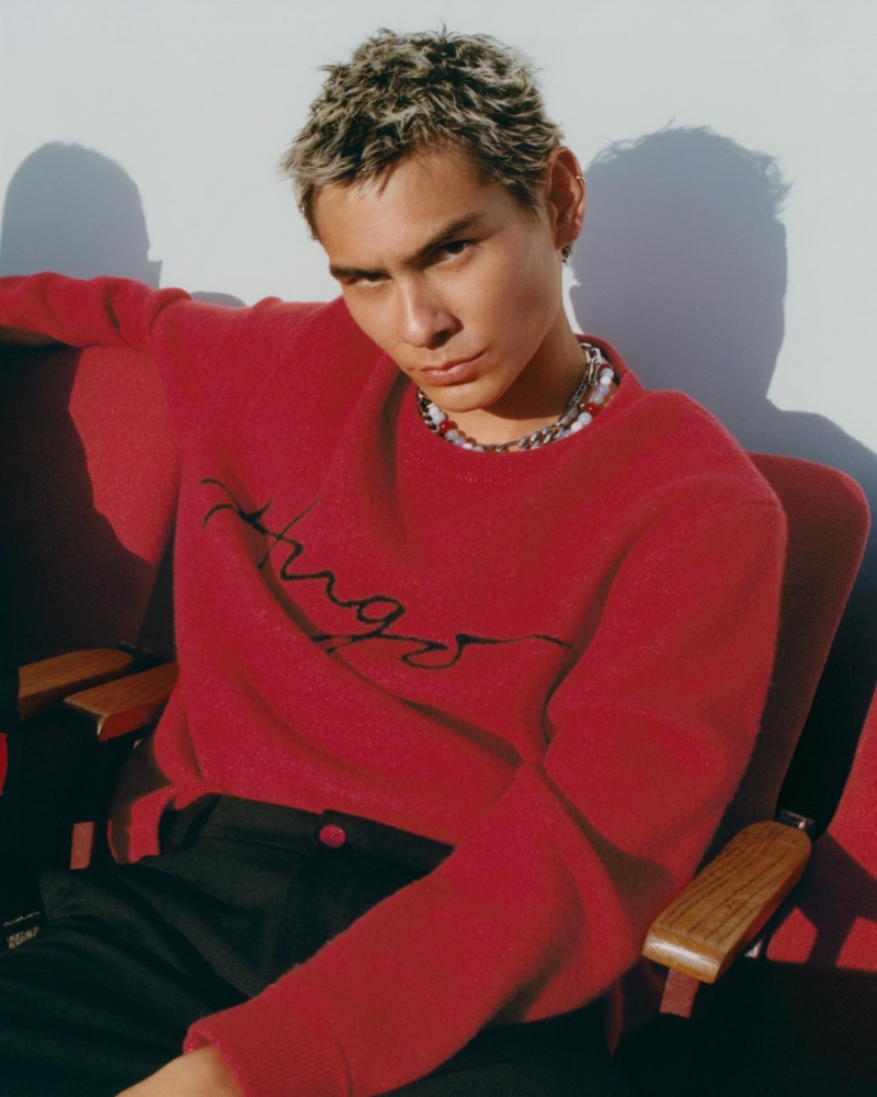 Evan Mock sports a red HUGO sweater for the brand's spring-summer 2023 campaign.