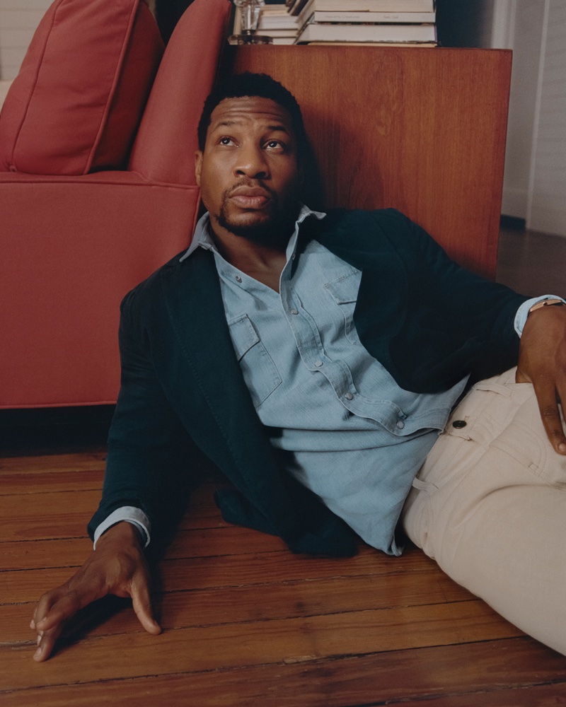 Embracing smart-casual style, Jonathan Majors dons a Sid Mashburn suit jacket with a Brunello Cucinelli denim western shirt, and Loro Piana jeans. 