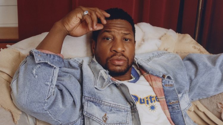 Jonathan Majors wears an Enfants Riches Déprimés denim trucker jacket with a Polite Worldwide t-shirt, OrSlow jeans, and a Hatton Labs necklace.