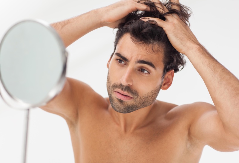 Man Looking at Hair in Mirror Man Looking at Hair in Mirror