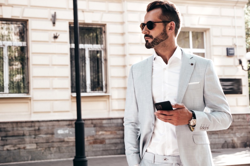 Man Outside Pale Gray Suit Sunglasses Watch Phone