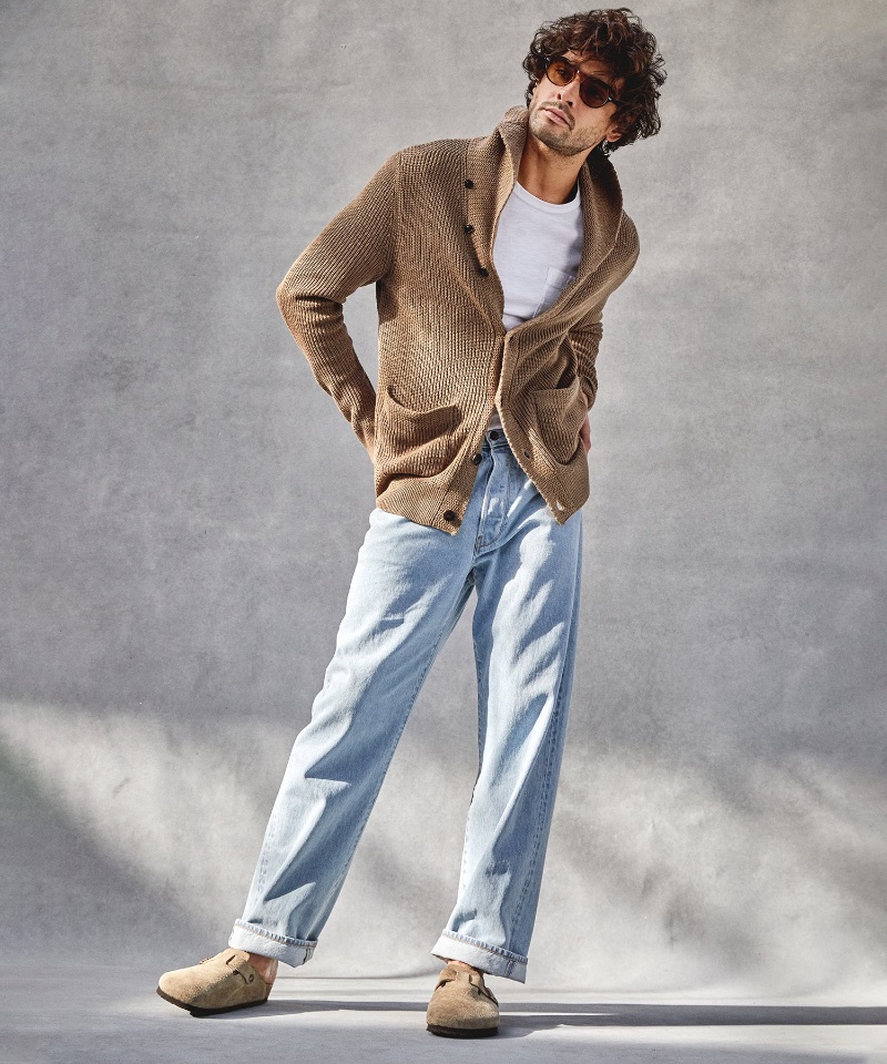 Brazilian model Marlon Teixeira embraces a laid-back Todd Snyder look in relaxed fit selvedge jeans in a sun faded wash with a cardigan sweater.