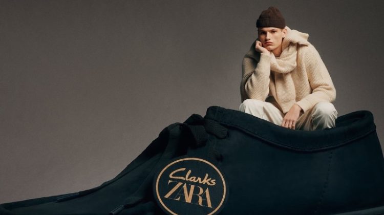 Model Louis Göckenjan poses inside an oversized leather shoe for the Clarks x Zara collection.