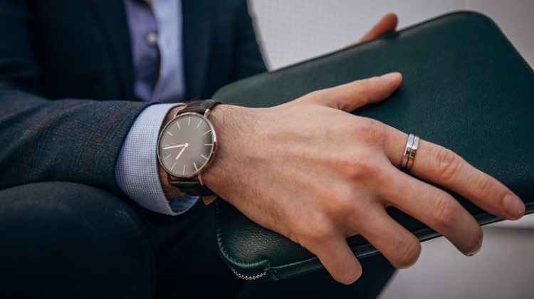 Man Wearing Watch Wedding Band Holding Leather Accessory