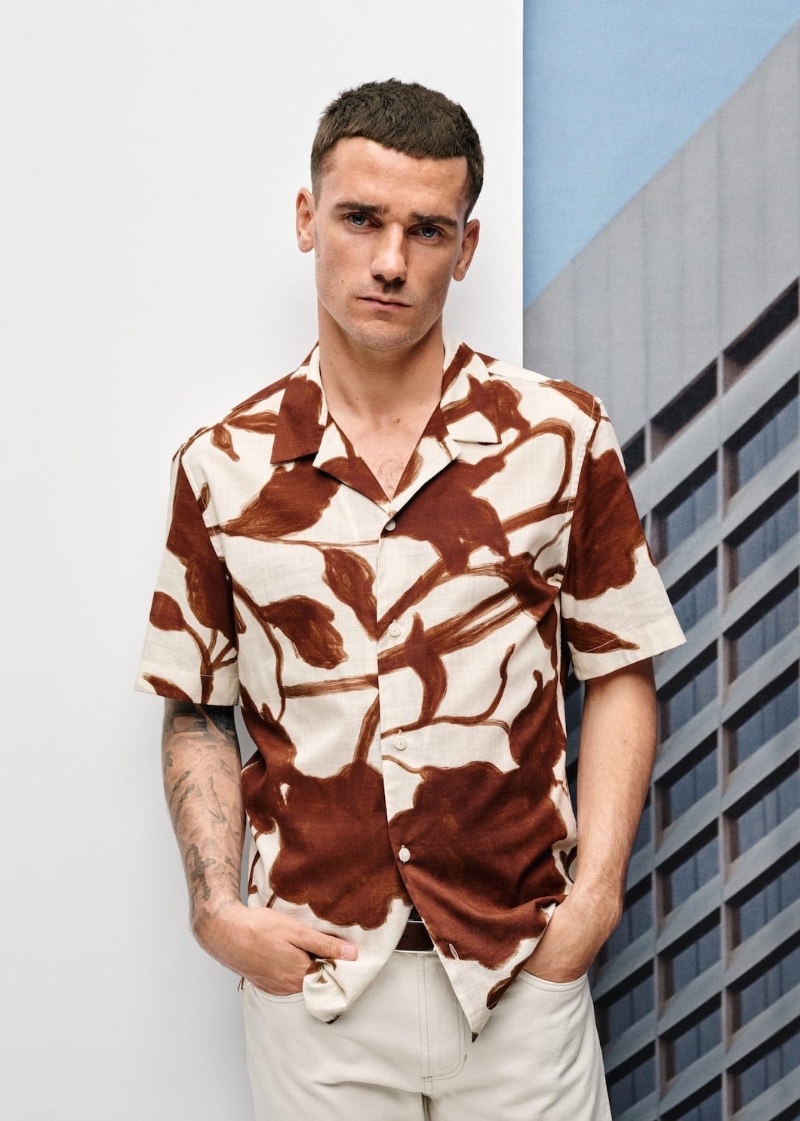 Taking up the spotlight for Mango once more, Antoine Griezmann sports a printed bowling shirt for the brand's spring-summer 2023 campaign.
