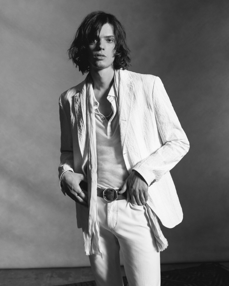 Erin Mommsen wears a white jacket, henley, and jeans from John Varvatos' spring 2023 collection.