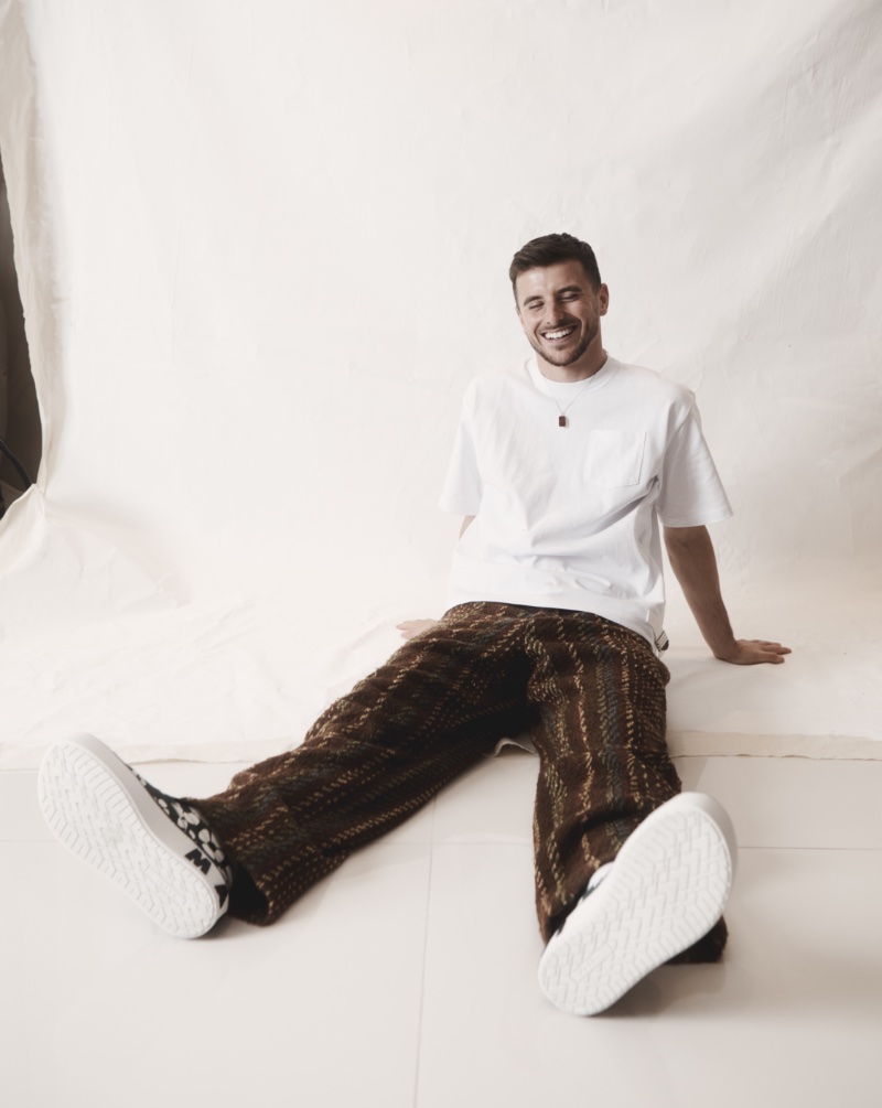 All smiles, Mason Mount wears a Sacai t-shirt, Marni x Carhartt sneakers, Our Legacy pants, and a Yvonne Leon necklace. 