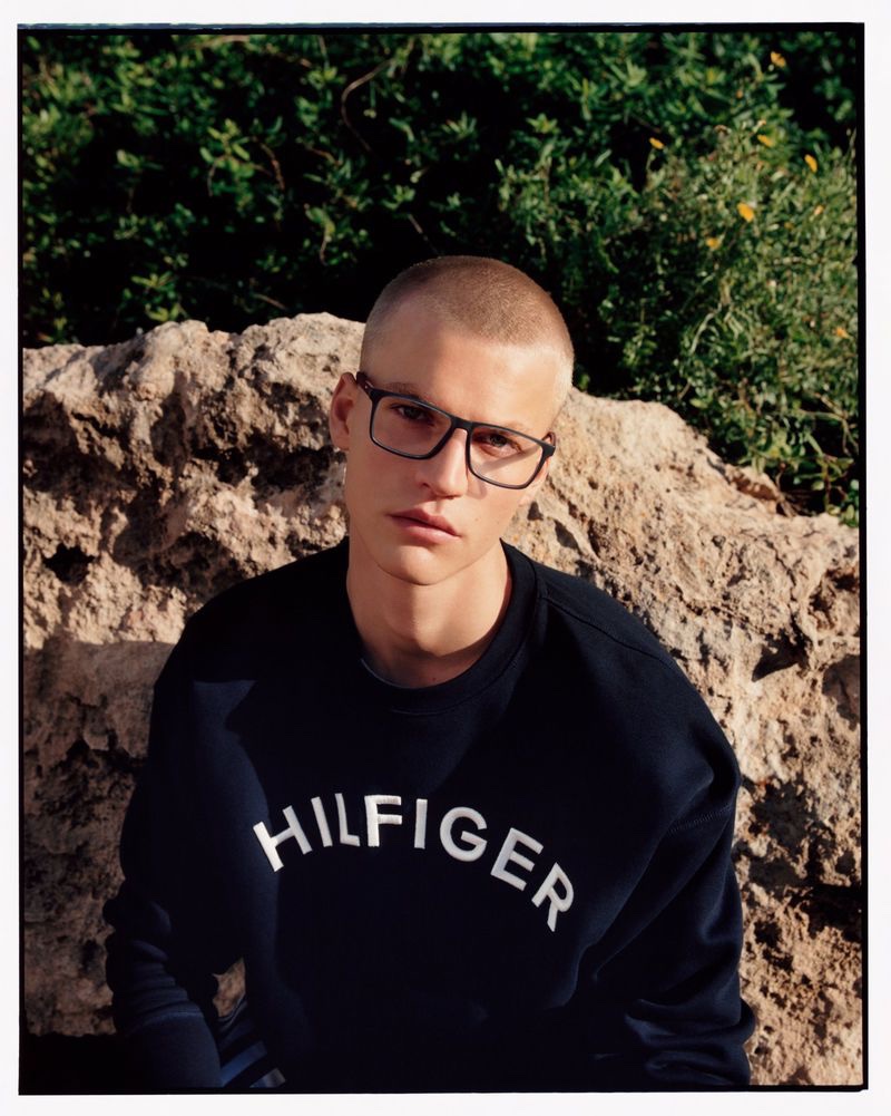 Wearing dark-framed glasses, Timo Pan fronts Tommy Hilfiger's spring-summer 2023 accessories campaign.